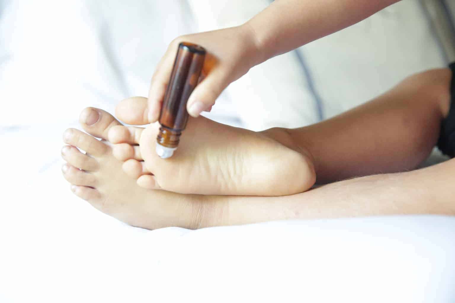 Applying essential oil roller bottom to foot.