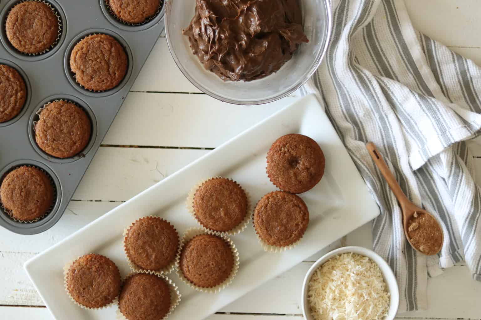 Fresh baked vanilla cupcakes on wooden table.