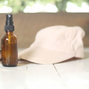 sunglasses hat and spray bottle on white table