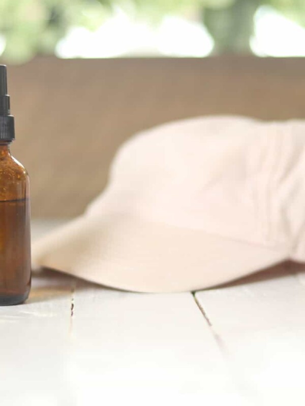 sunglasses hat and spray bottle on white table