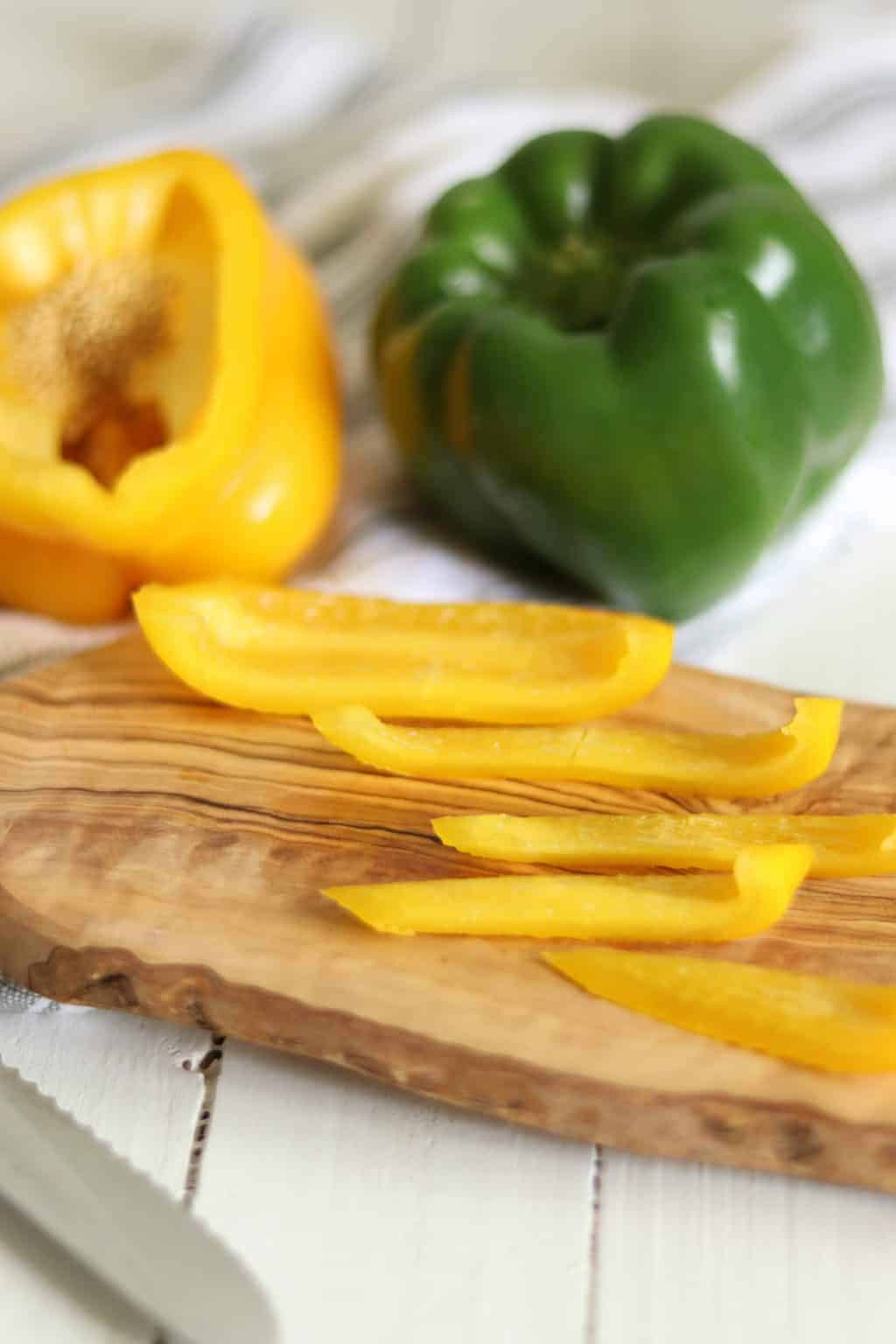 Some chopped yellow peppers on cutting board.