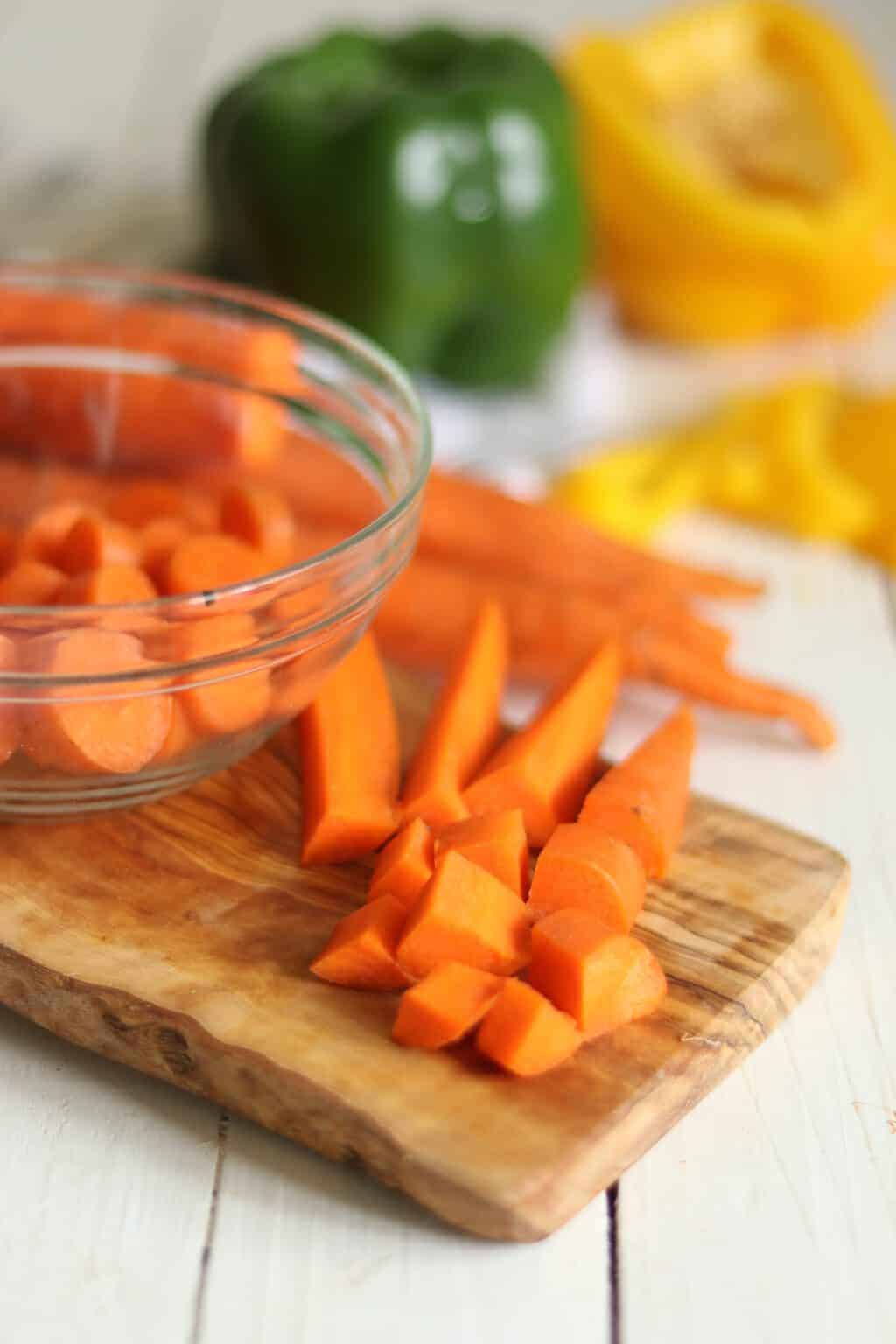 Chopped carrots on wooden cutting board.