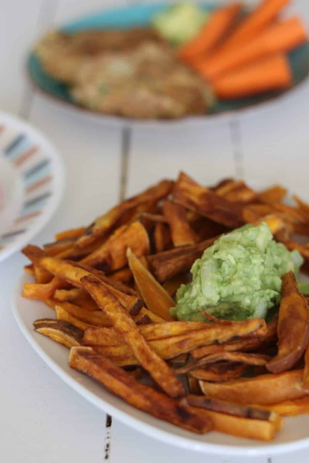 Sweet potato fries and guacamole dip on plate.