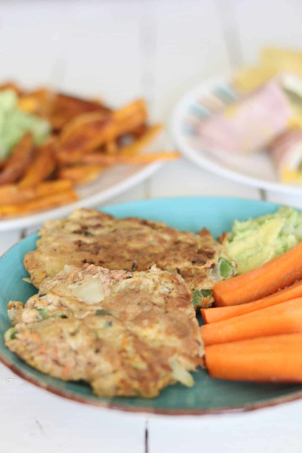 salmon burger guacamole carrots slices on plate