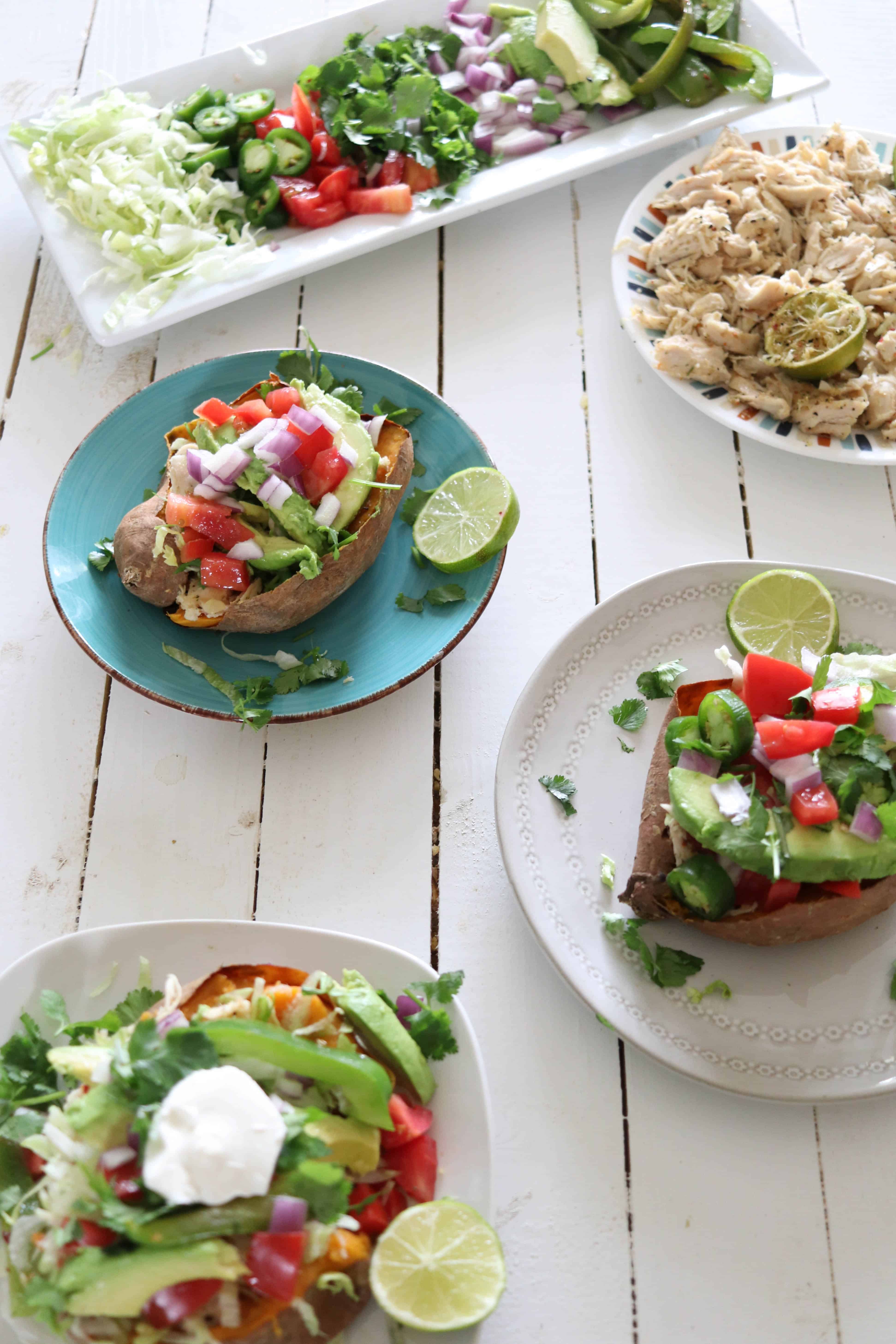 Mexican stuffed sweet potatoes with toppings on white platter.