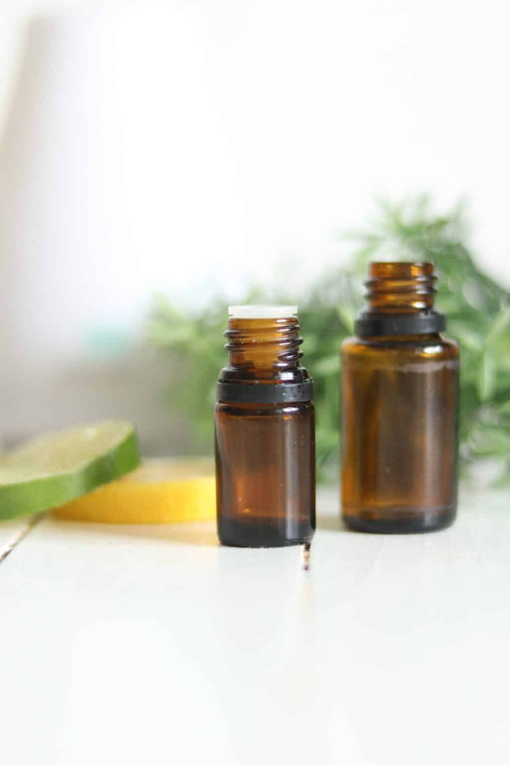 10ml and 15ml essential oil bottles with fresh lime and lemon slices.
