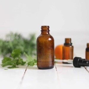 Chlorine detoxing spray in a glass bottle on a white board table.