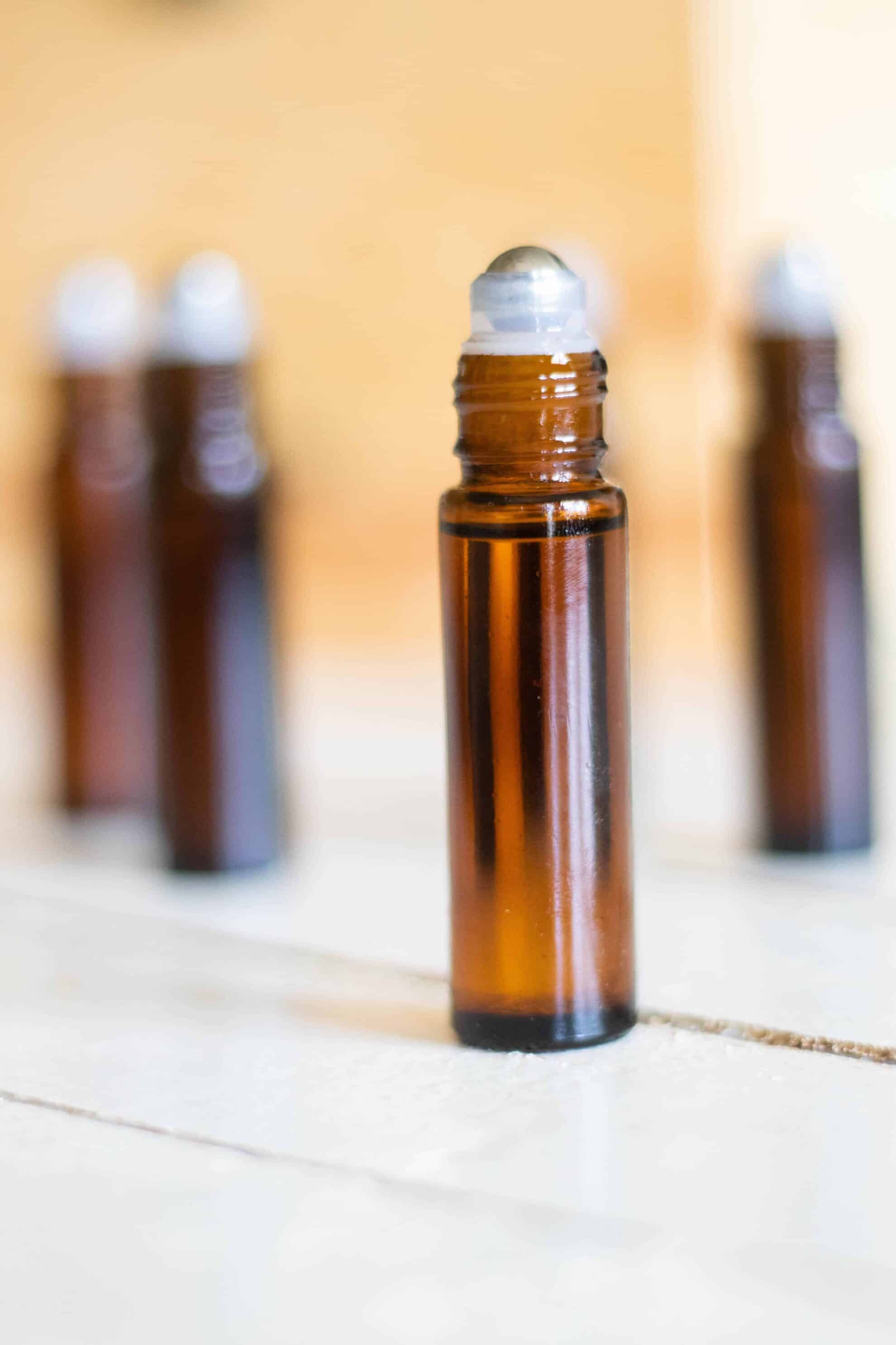 10mL amber glass rollerballs on white table top.