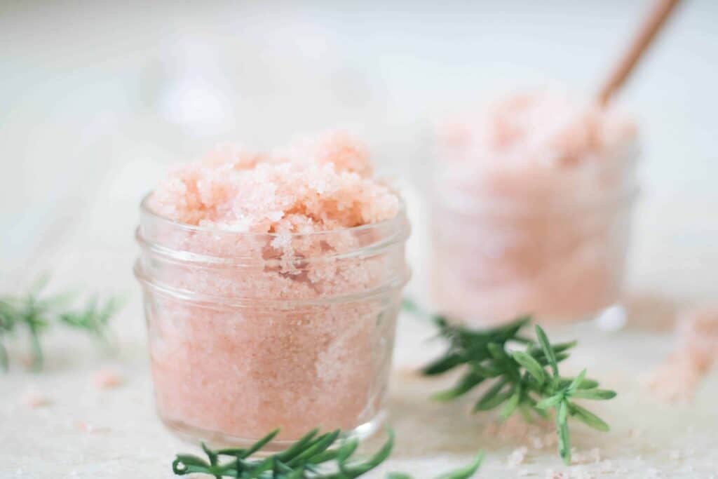A DIY foot scrub made from pink salt in two glass shallow jars.