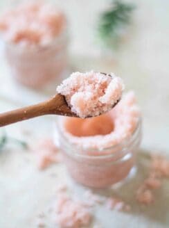 pink foot scrub on wooden spoon and small mason jar