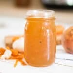 homemade bone broth in tall glass mason jar.