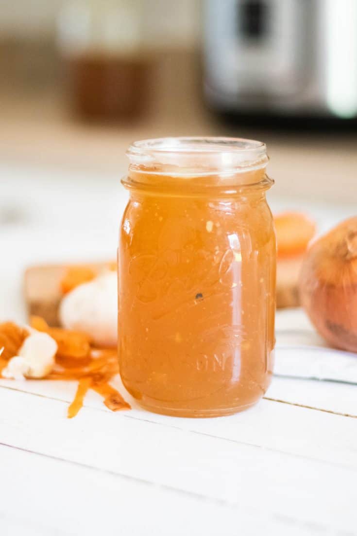 homemade bone broth in tall glass mason jar.