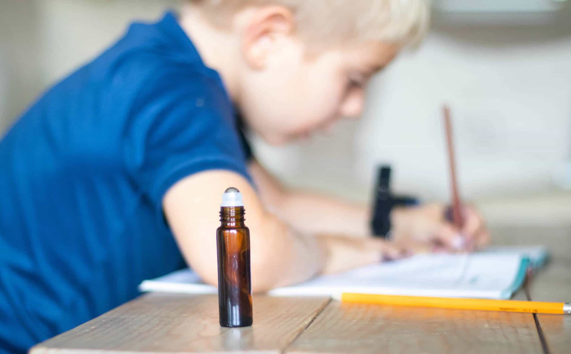 Roller bottle by little boy doing homework.