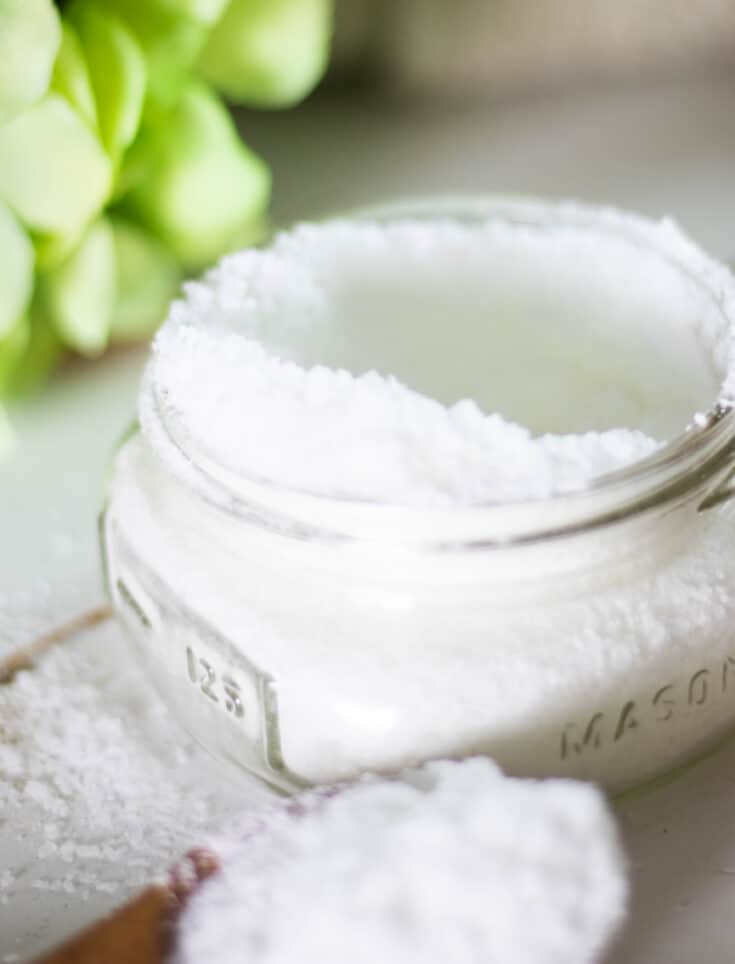 white powder in wide mouth mason jar and wooden measuring spoon
