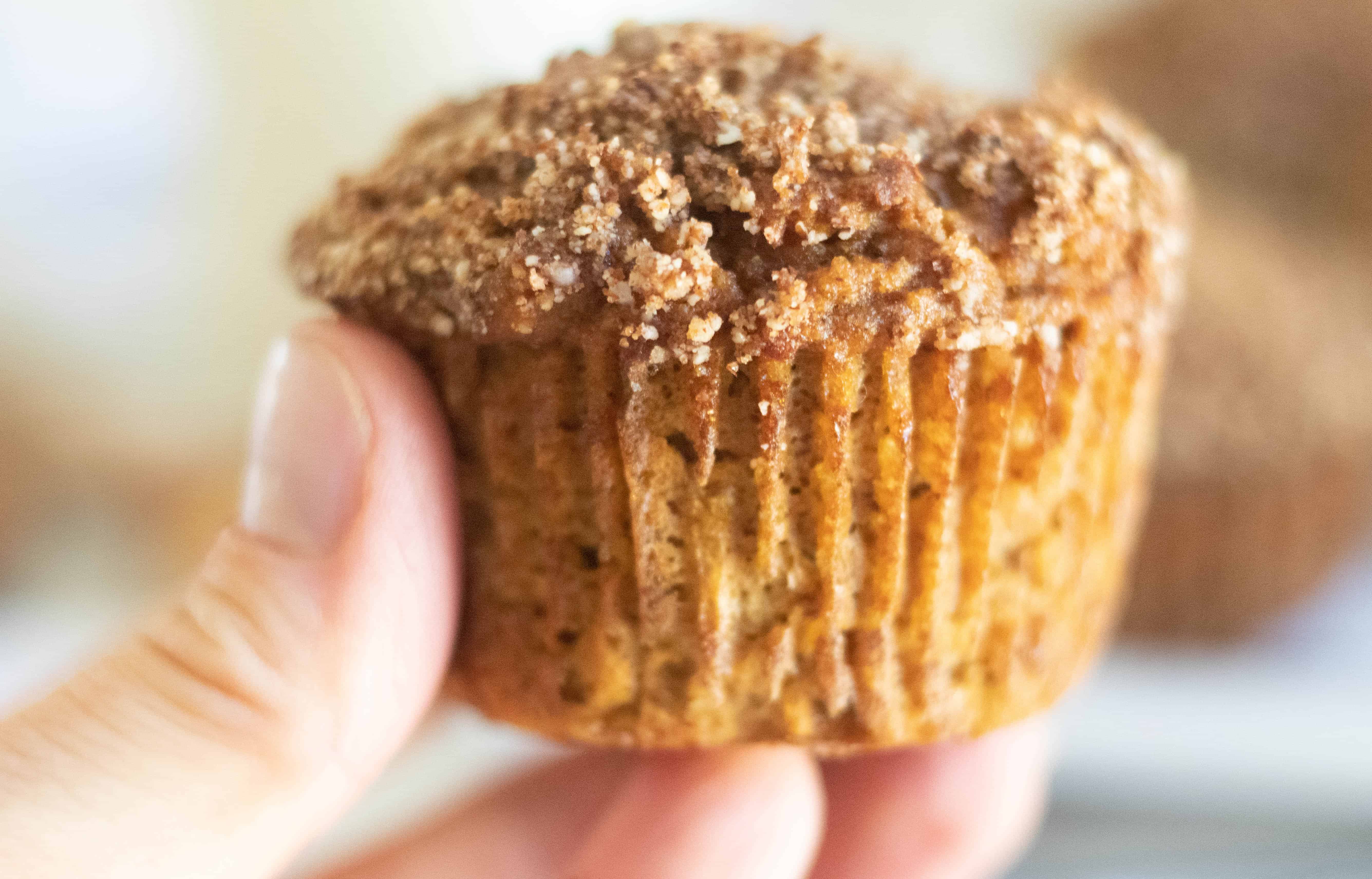 Hand holding a pumpkin muffin.