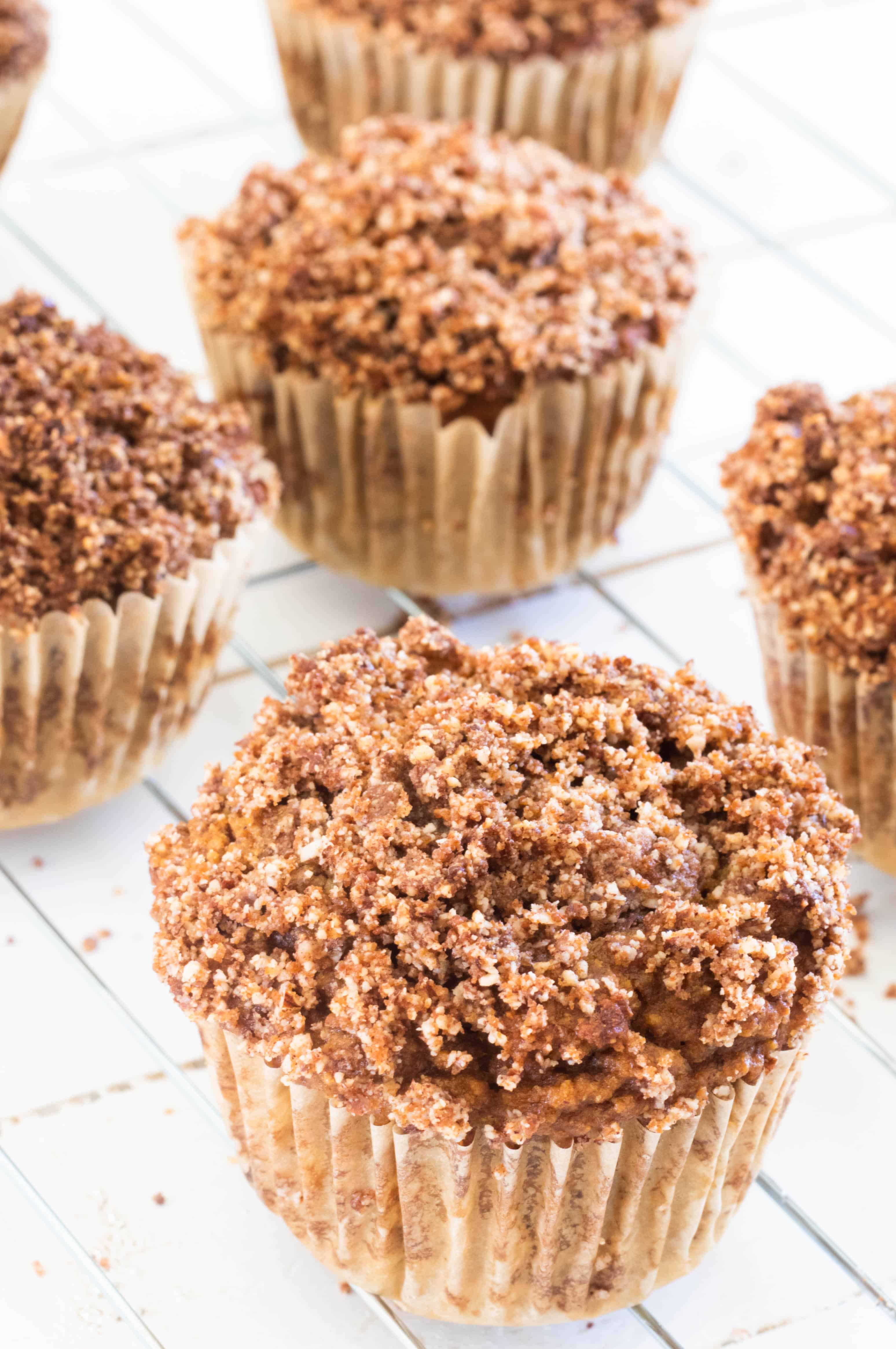 Pumpkin muffins with crumble topping on cooling wire rack.