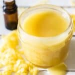 yellow beeswax sprinkled around small mason jar of homemade vapor rub