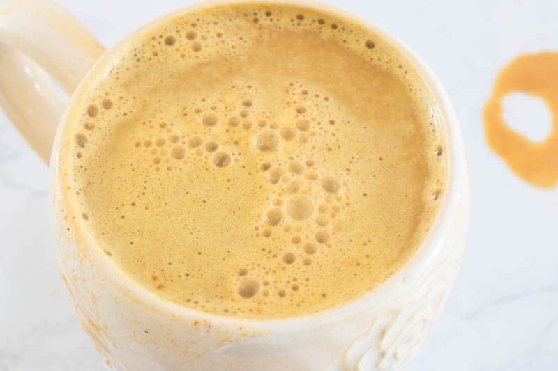 Whole 30 pumpkin spice latte in cream coffee mug on table.