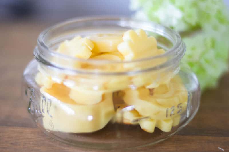 Wide-mouth mason jar filled with bees wax candle melts.