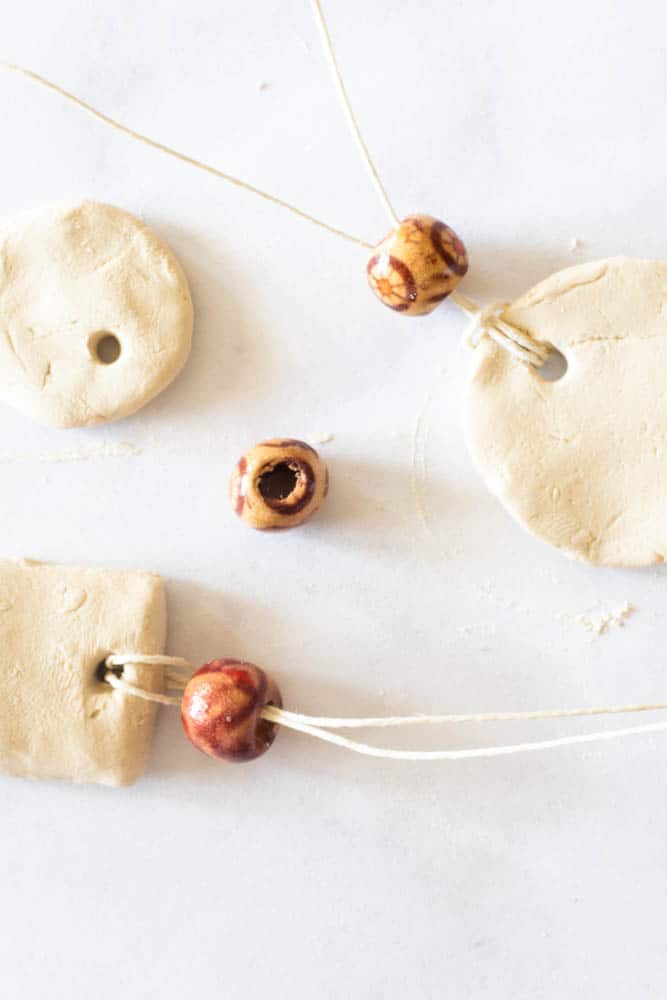 Clay diffuser necklaces with wooden beads and white string.