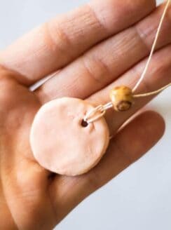 clay diffuser necklace in palm of hand
