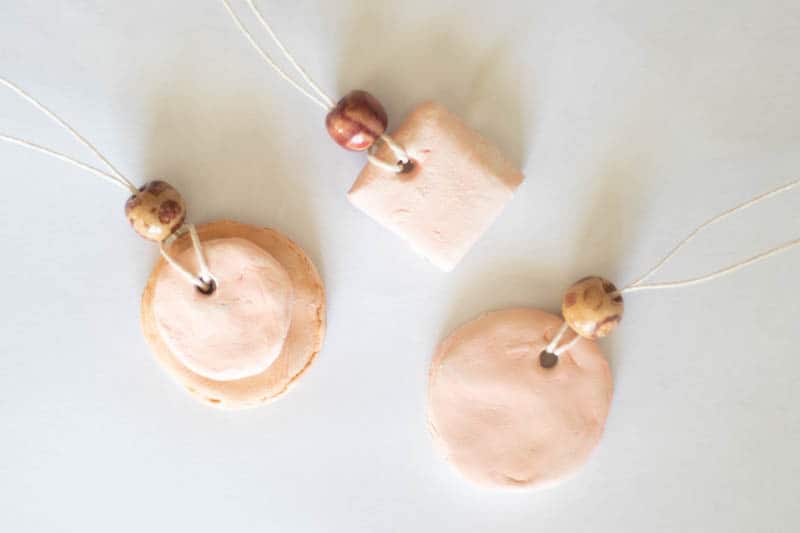 Homemade diffuser necklaces on white background.