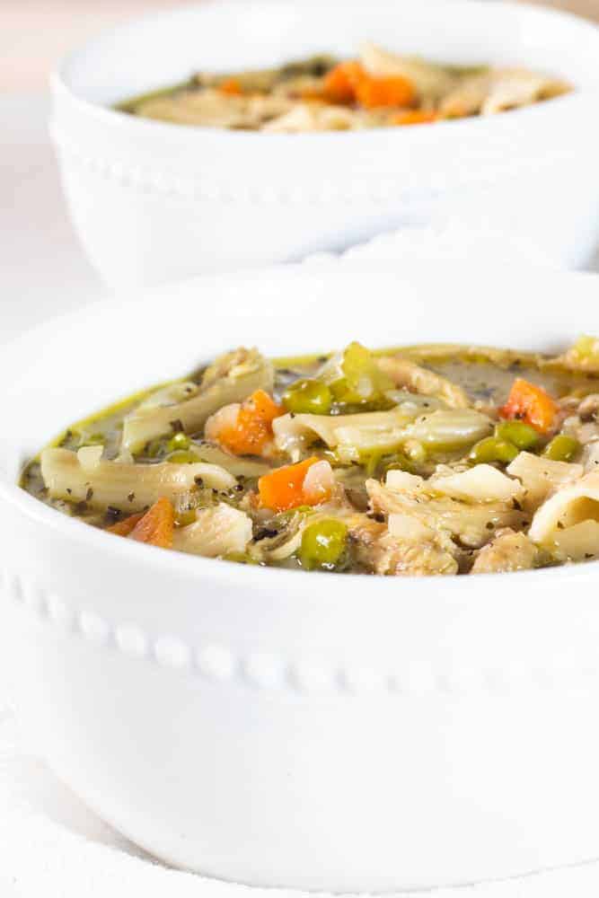 Healthy turkey noodle soup in white bowl.