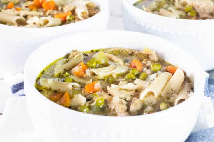 turkey noodle vegetable soup in white bowls