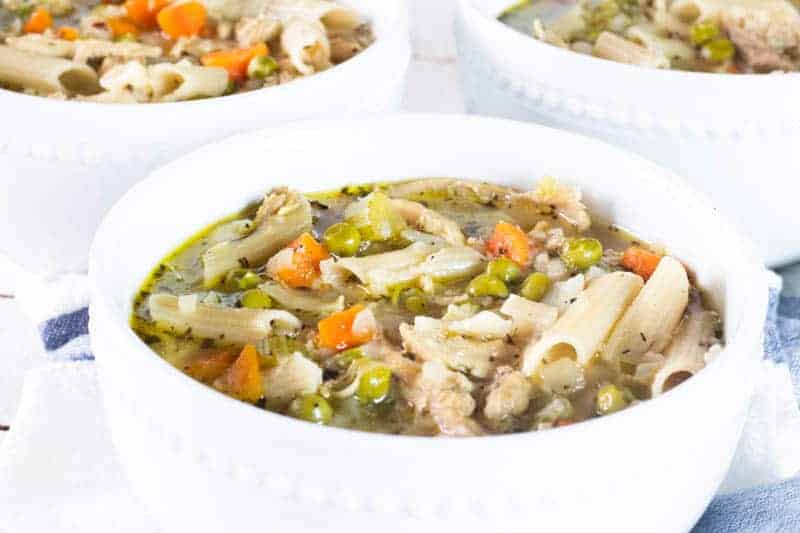 White bowls filled with turkey noodle soup.