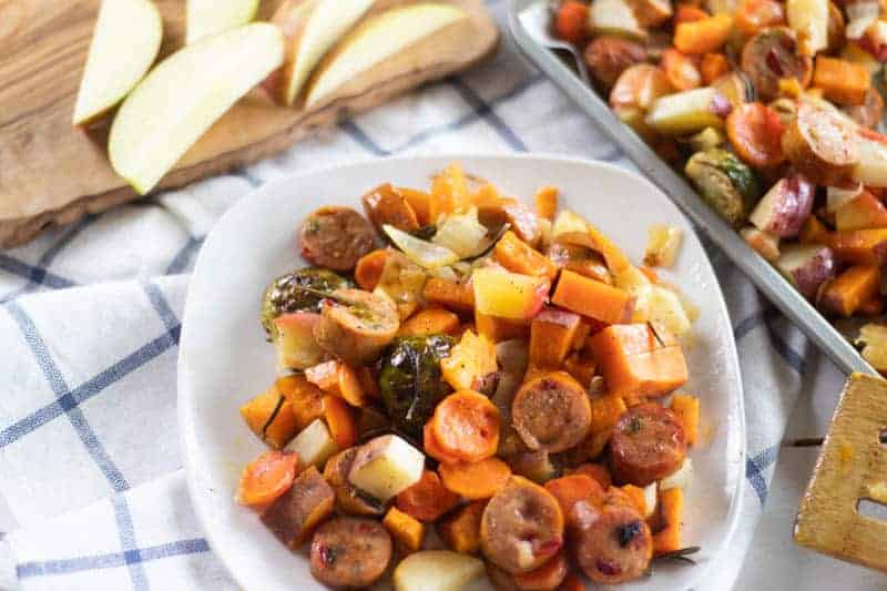 White plate of roasted sausage and vegetables.