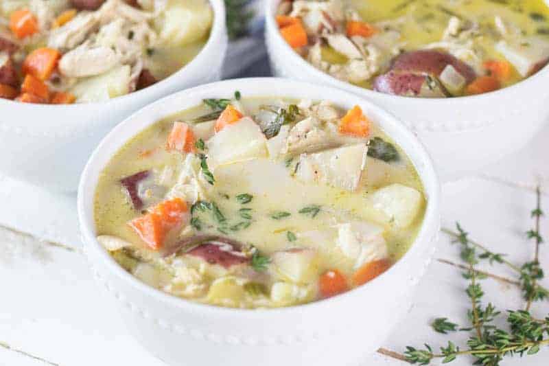 Three white bowls of creamy whole 30 approved chicken soup.