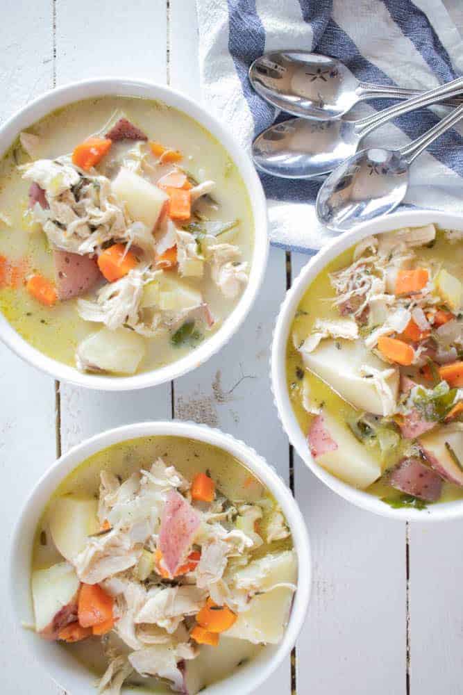 Bowls of whole30 chicken vegetable soup on white shiplap.