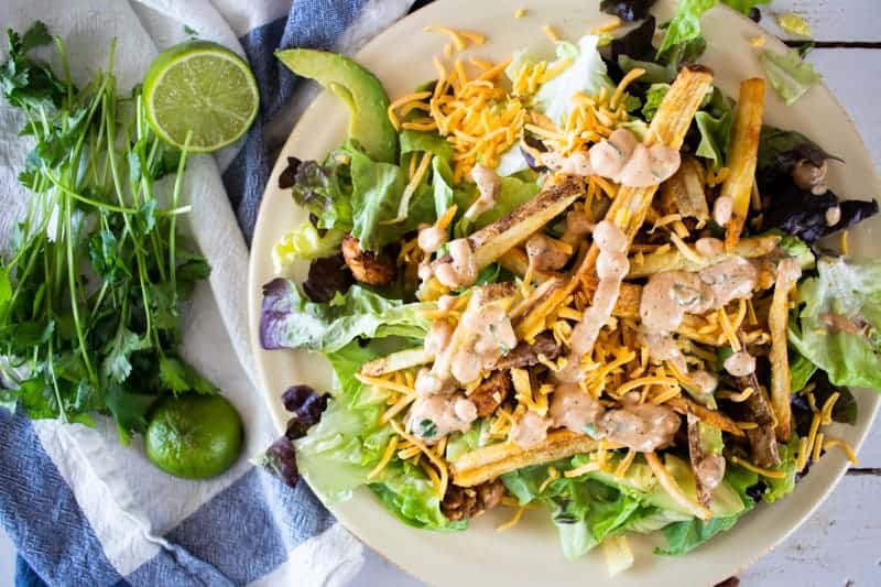 Southwest chicken salad on tan plate with lime and cilantro.