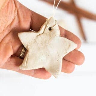 hand holding a white clay diffuser ornament