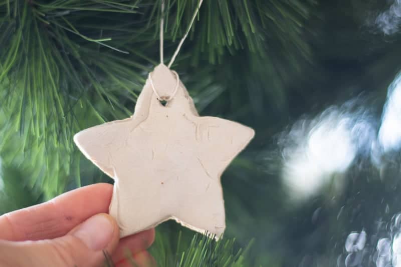 Hanging white star ornament on the Christmas tree.