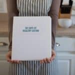 hands holding cookbook in kitchen