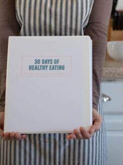 hands holding cookbook in kitchen