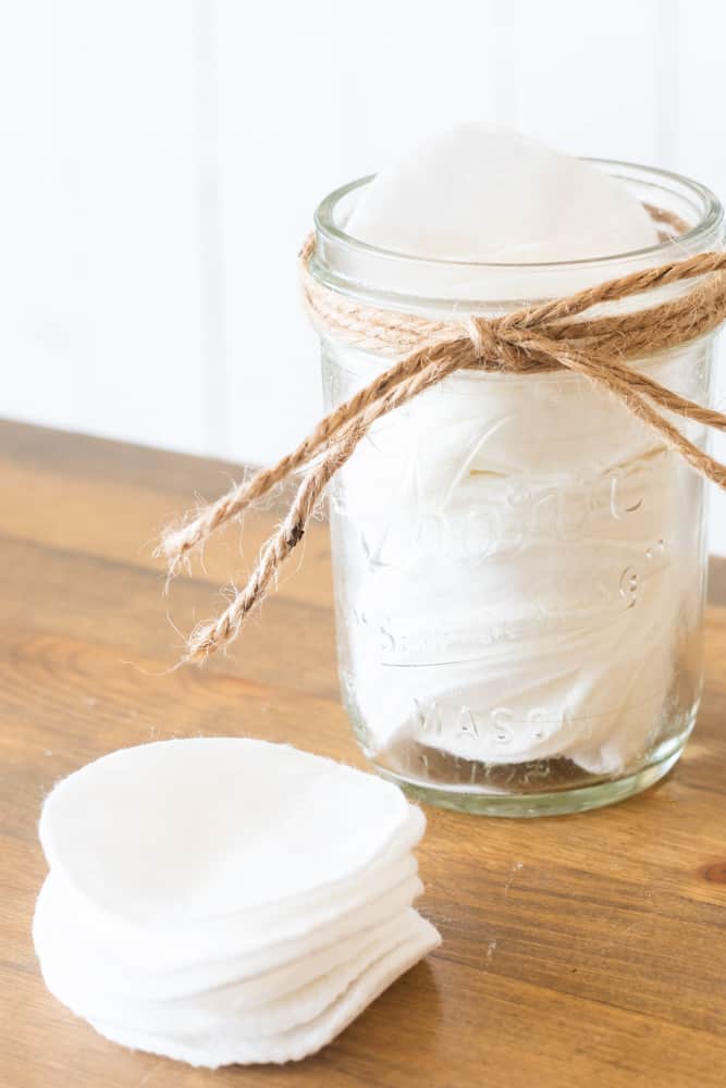Makeup wipes in mason jar and on wood table.