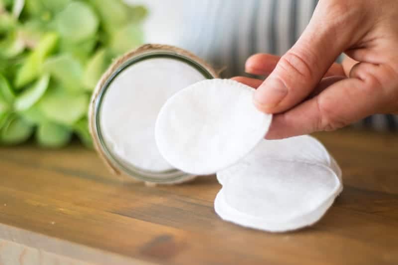 Cloth makeup remover wipes on wooden table.