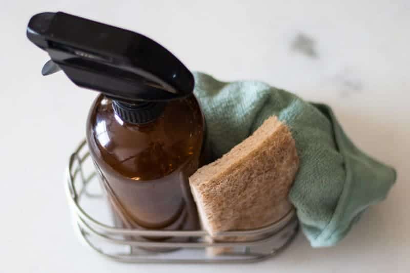 DIY granite cleaner spray in a small wire basket.