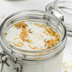 Oatmeal milk bath with dried flowers in mason jars.