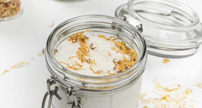Oatmeal milk bath with dried flowers in mason jars.