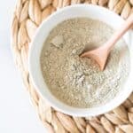 bentonite clay in white bowl with wooden spoon in it