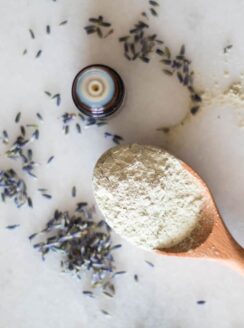 powder clay on wooden spoon with lavender springs around it