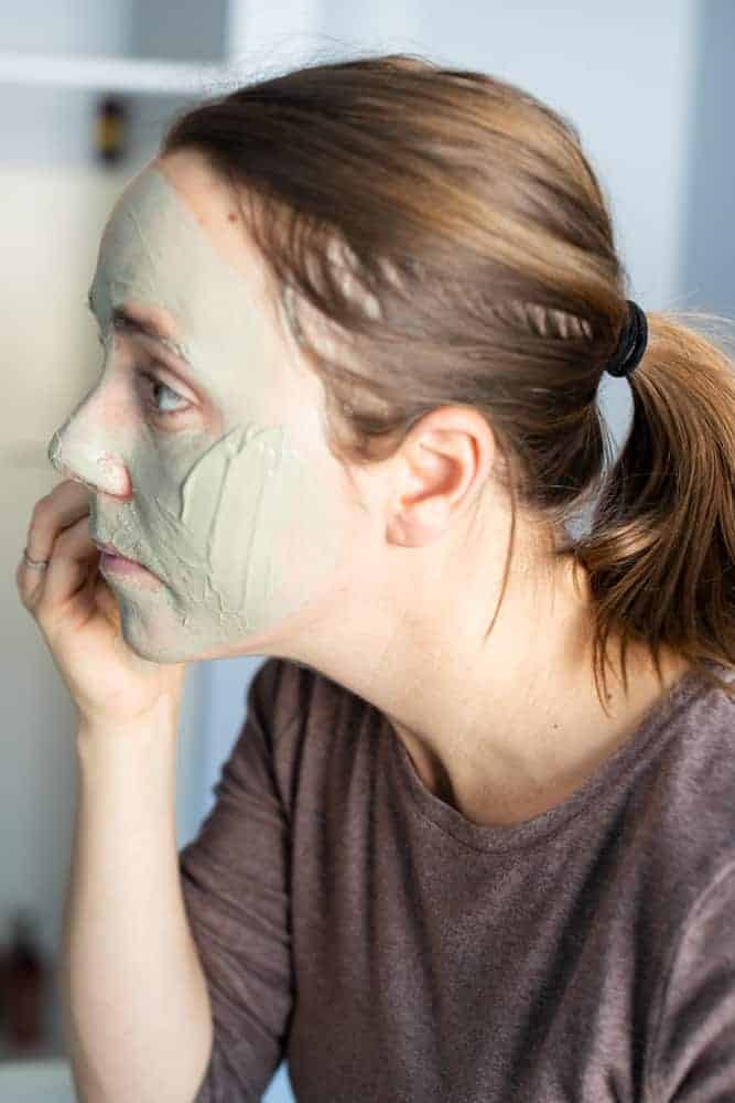 applying bentonite clay face mask 