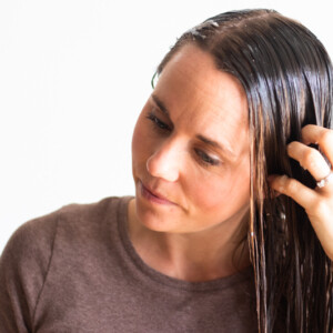 Using hands to apply a natural hair mask to wet hair.