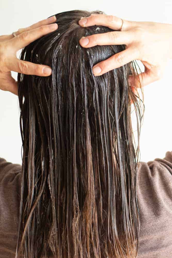 Rubbing a diy hair mask into long damp hair.