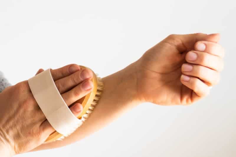 Dry brushing the forearm with a dry brush.