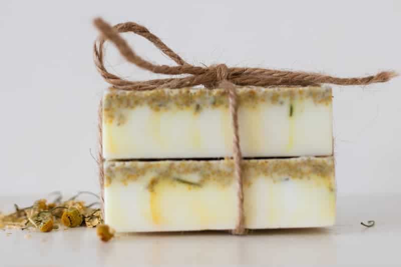 two homemade soap bars with dried flowers tied together with hemp string