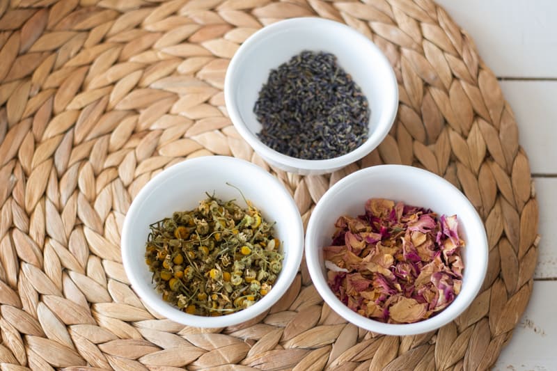 white bowls of dried flowers on round woven mat